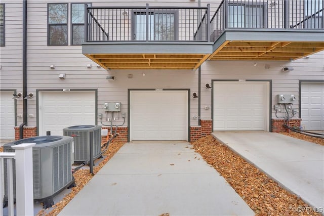 garage with central AC unit and concrete driveway