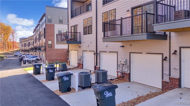 exterior space with brick siding, a garage, and central AC