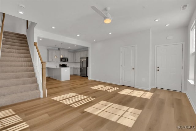 unfurnished living room featuring light hardwood / wood-style flooring and ceiling fan