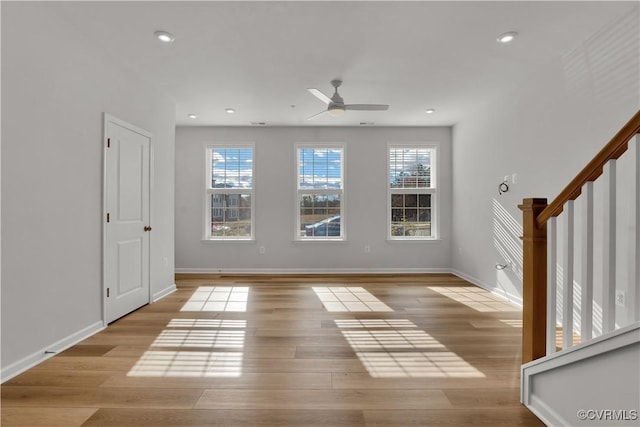 empty room featuring plenty of natural light, light hardwood / wood-style floors, and ceiling fan