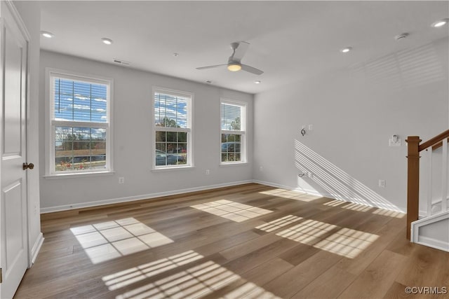 unfurnished room featuring hardwood / wood-style flooring, a wealth of natural light, and ceiling fan