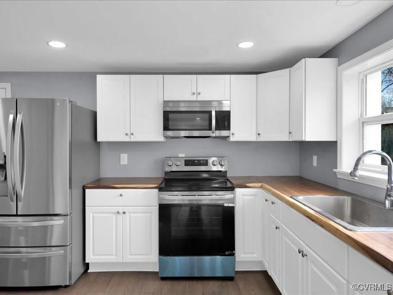 kitchen with white cabinetry, stainless steel appliances, and sink