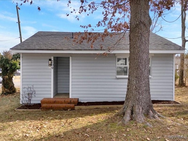 rear view of property with a yard and an outdoor structure