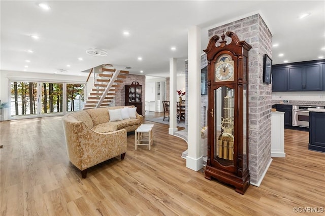 living room with stairs, recessed lighting, and light wood-style floors