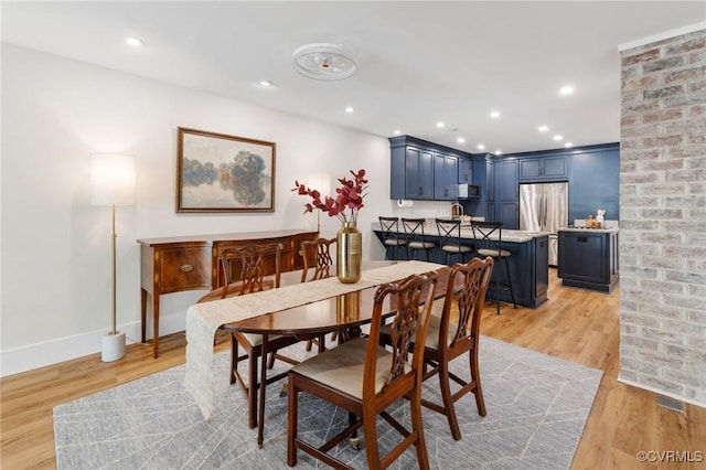 dining space featuring light wood finished floors, baseboards, and recessed lighting