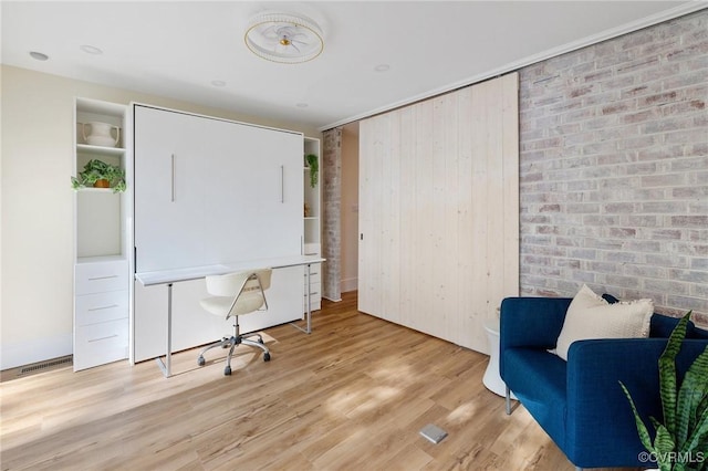 office featuring brick wall, wood finished floors, and visible vents