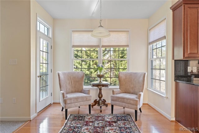 living area featuring light wood-style flooring and baseboards