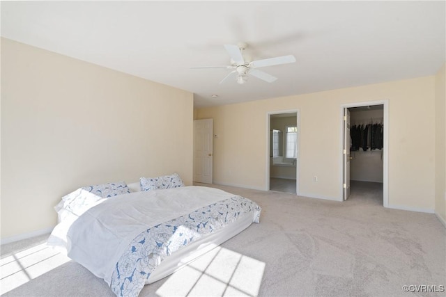 bedroom with carpet floors, a ceiling fan, baseboards, a spacious closet, and a closet