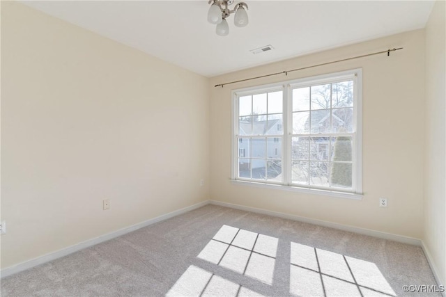 spare room with light colored carpet, visible vents, and baseboards