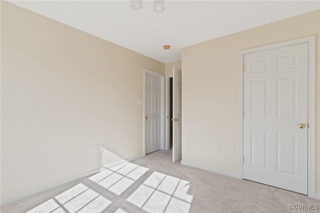 unfurnished bedroom with light carpet and baseboards