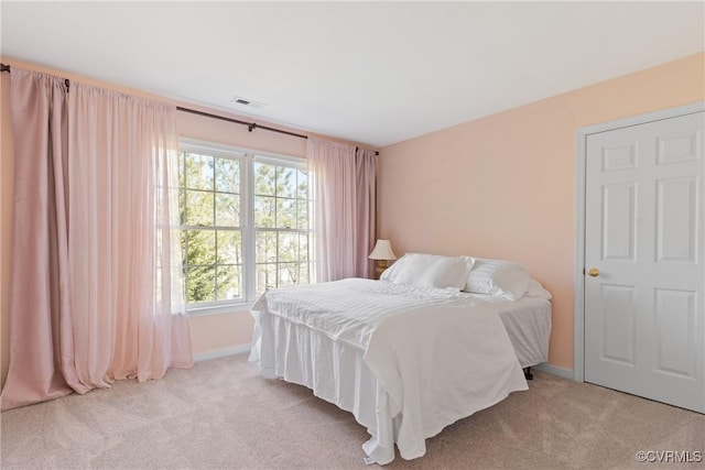 carpeted bedroom featuring baseboards and visible vents