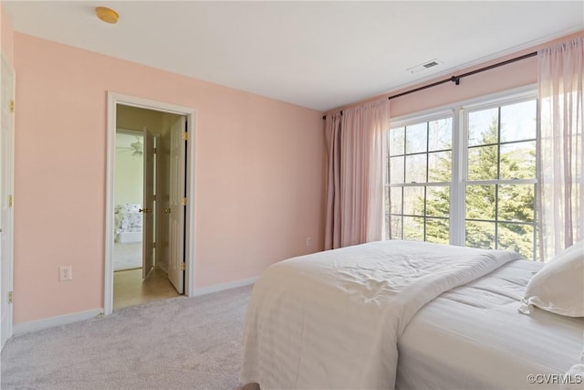 bedroom with baseboards, visible vents, and light colored carpet