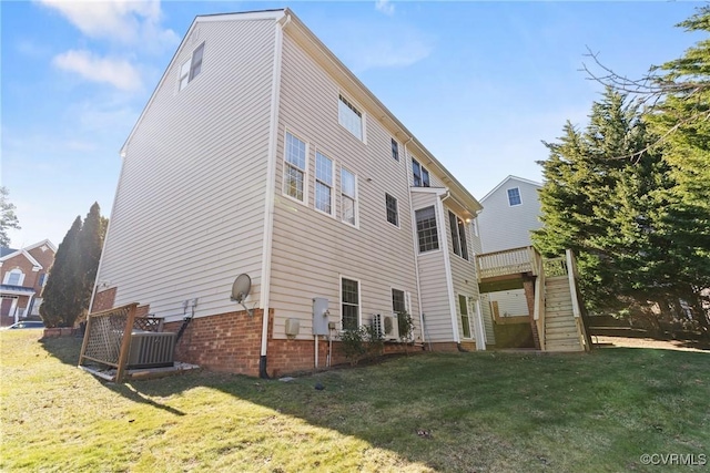 back of house featuring stairs and a yard