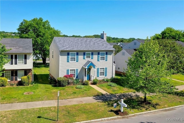 view of front of property featuring a chimney and a front yard