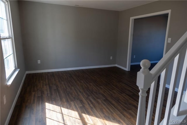 unfurnished room featuring dark wood-style floors and baseboards