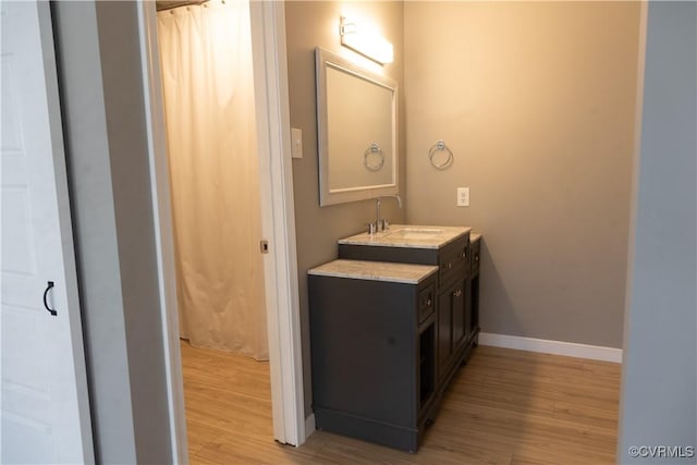 bathroom with vanity, baseboards, and wood finished floors