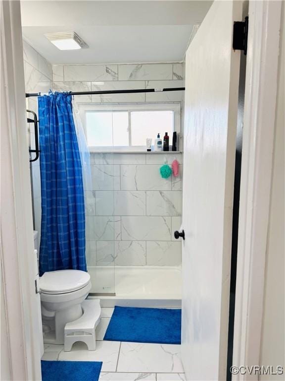 bathroom with toilet and a shower with curtain