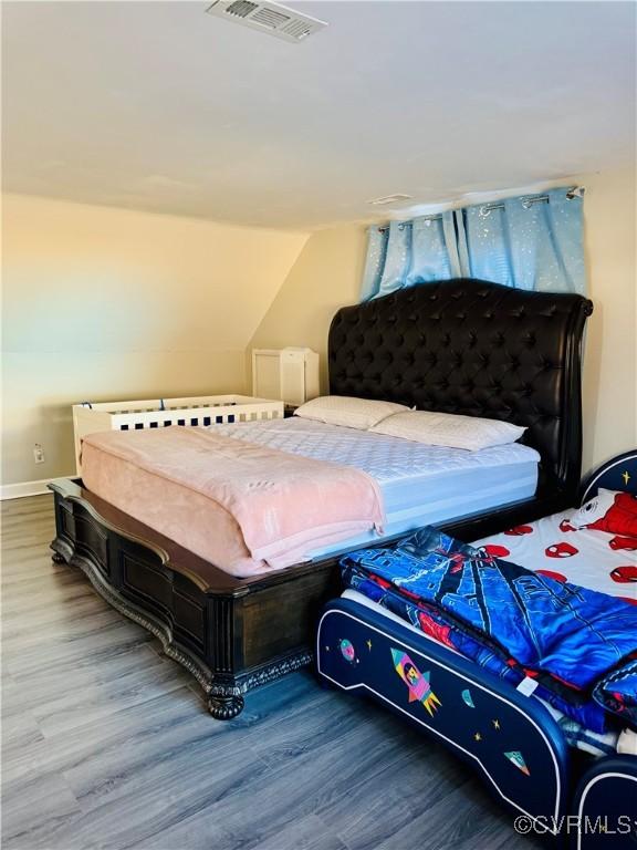 bedroom featuring lofted ceiling and wood-type flooring