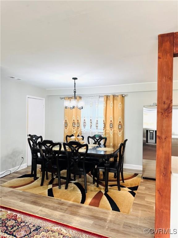 dining area featuring an inviting chandelier and light hardwood / wood-style flooring