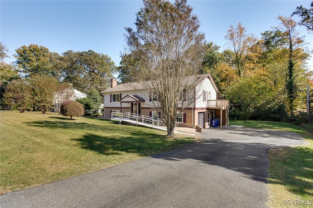 view of front of property with a garage, a front yard, and a deck