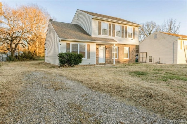 view of front of house with a front yard and brick siding