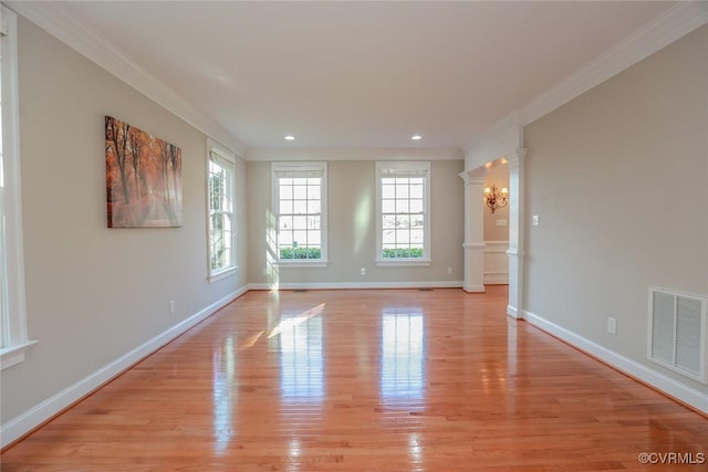 spare room featuring ornamental molding and light hardwood / wood-style flooring