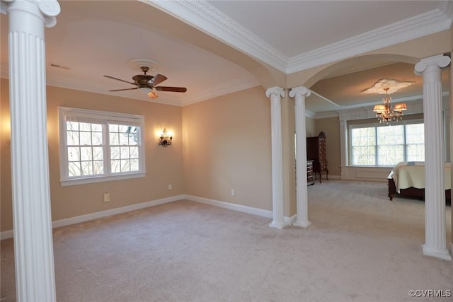 spare room with ornate columns, crown molding, ceiling fan with notable chandelier, and light colored carpet