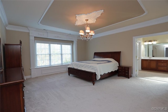 carpeted bedroom with a raised ceiling, ornamental molding, connected bathroom, and a chandelier