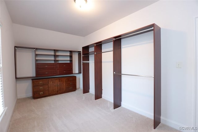 walk in closet with light colored carpet