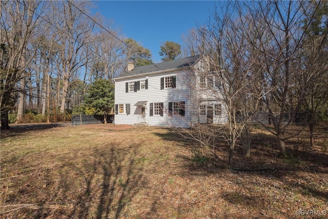 rear view of house featuring a lawn