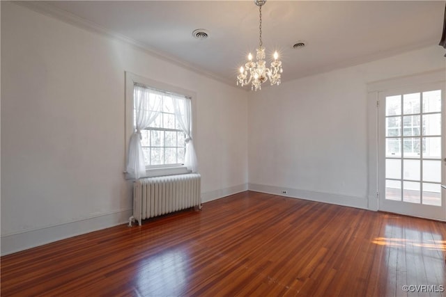 unfurnished room featuring dark hardwood / wood-style floors, crown molding, radiator heating unit, and a notable chandelier