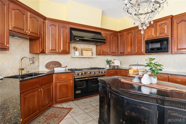 kitchen with black microwave, sink, a chandelier, range with two ovens, and wall chimney exhaust hood