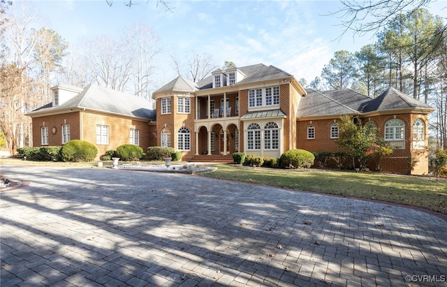 view of front facade featuring a balcony and a front lawn