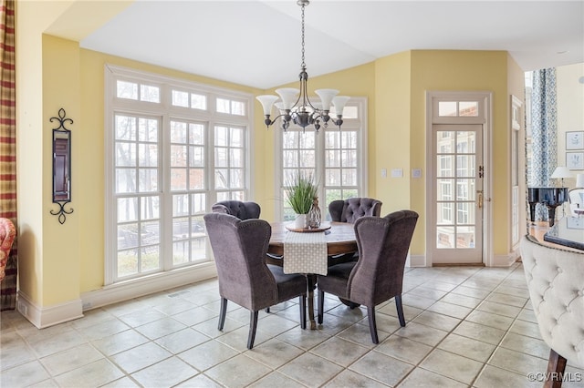 tiled dining room with lofted ceiling and a notable chandelier