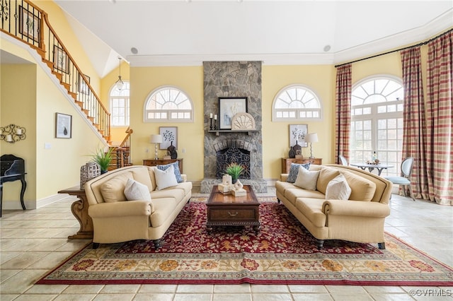 living room with a fireplace, crown molding, plenty of natural light, and light tile patterned flooring