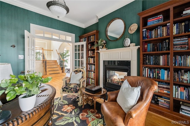 sitting room featuring hardwood / wood-style flooring, a multi sided fireplace, and ornamental molding