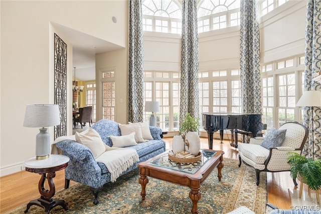 sitting room with a high ceiling, wood-type flooring, and plenty of natural light