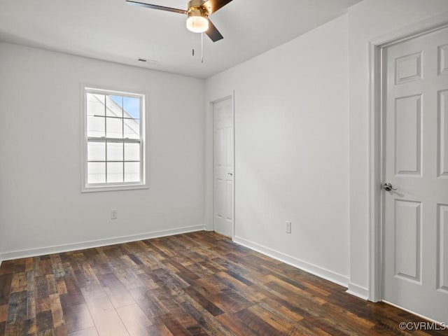 empty room featuring dark hardwood / wood-style flooring and ceiling fan