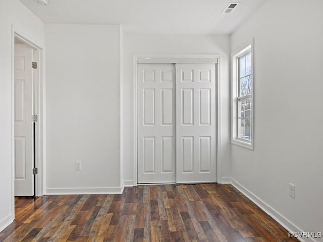 unfurnished bedroom featuring dark hardwood / wood-style floors and a closet