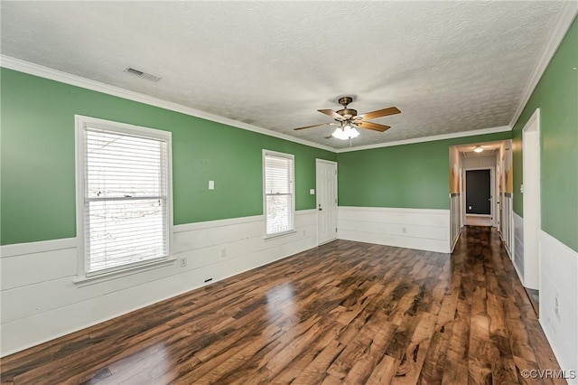 spare room with ceiling fan, ornamental molding, dark hardwood / wood-style flooring, and a textured ceiling