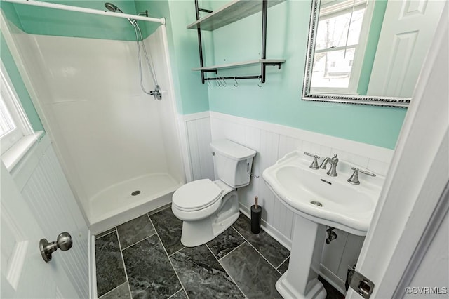 bathroom featuring sink, toilet, and a shower