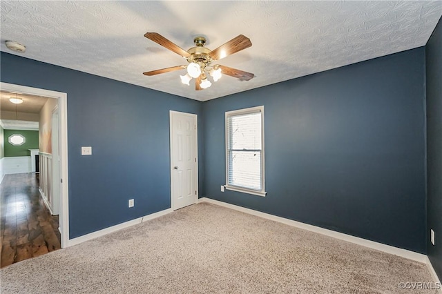 empty room with ceiling fan and a textured ceiling