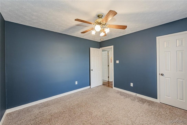 empty room featuring ceiling fan, carpet floors, and a textured ceiling