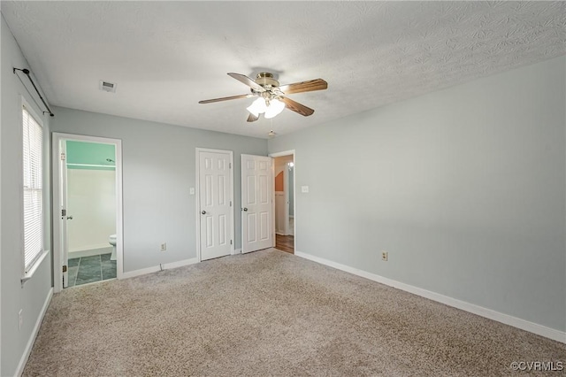 unfurnished bedroom featuring ensuite bathroom, carpet, ceiling fan, and a textured ceiling