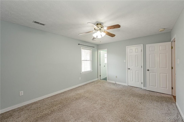 unfurnished bedroom featuring a closet, ceiling fan, carpet, and a textured ceiling