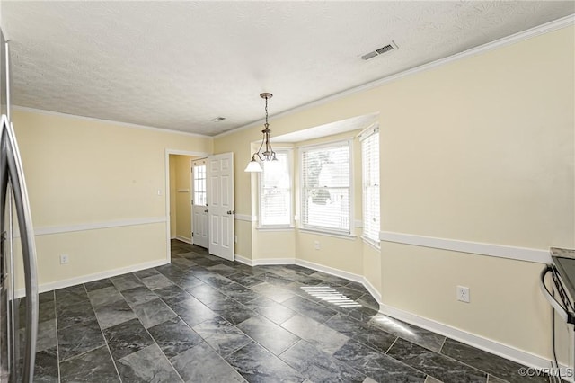 unfurnished dining area with ornamental molding and a textured ceiling