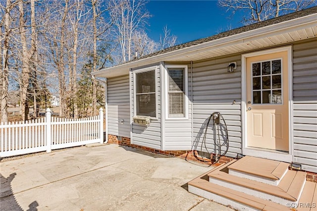 view of exterior entry with a patio