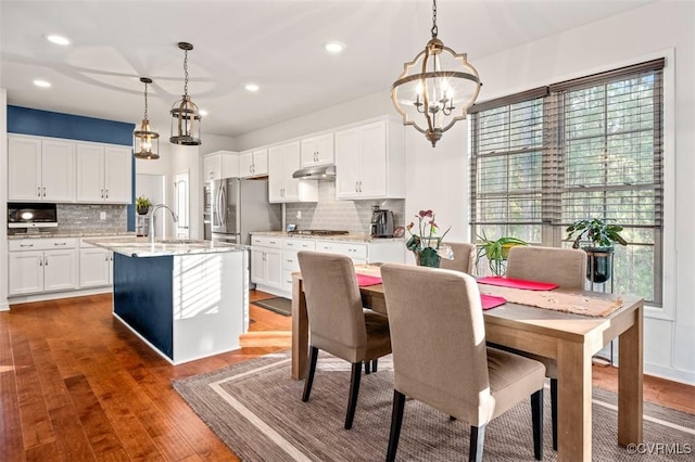 dining area with dark wood-style flooring, a notable chandelier, and recessed lighting