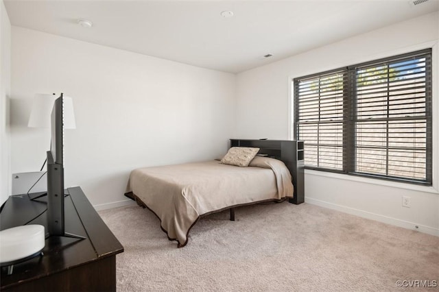 carpeted bedroom featuring visible vents and baseboards