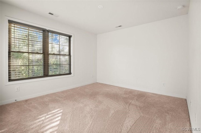 unfurnished room featuring carpet and visible vents